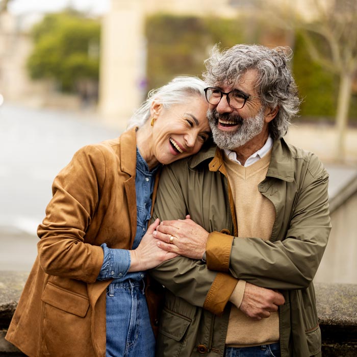 laughing senior couple walking down street