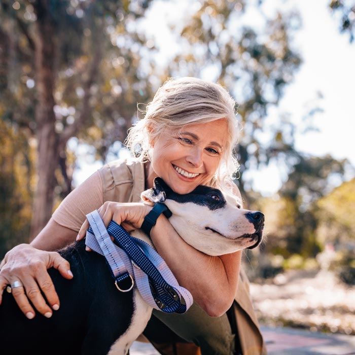smiling senior woman hugging her dog